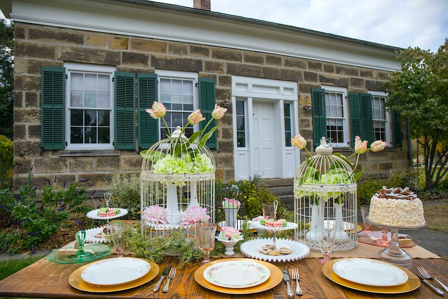 Outdoor celebration tablescape with vintage birdcages and china